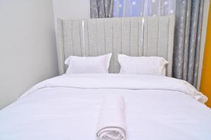 a large white bed with white sheets and pillows at GILGAL Homes in Kisii +4 photos