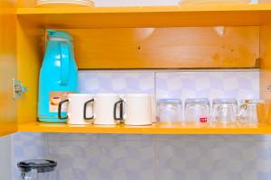 a shelf with glass jars and a blue bottle on it at GILGAL Homes in Kisii