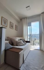 a white bedroom with a bed and a balcony at 1107 Ponte Laguna, Pq Burle Marx, Apto 1 dorm e Varanda in Sao Paulo