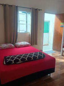 Un dormitorio con una cama roja con una manta roja. en Pousada Nossa Senhora Da Polônia, en Cachoeira Paulista
