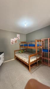 a bedroom with two bunk beds and a tv at Hospedaria Oceania in Bombinhas