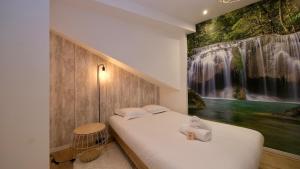 una camera da letto con un letto e un dipinto sul muro di Studio pratique et cosy Rouen centre a Rouen