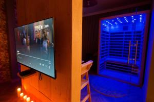 a flat screen tv sitting on a wooden stand next to a window at La détente in Lons-le-Saunier