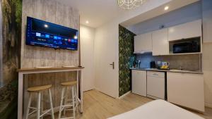 una cucina con bar e TV a parete di Studio pratique et cosy Rouen centre a Rouen