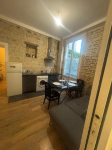 a living room with a table and a kitchen at New apartment rue de Fontenay in Vincennes