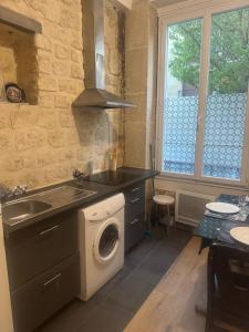 a kitchen with a washing machine and a sink at New apartment rue de Fontenay in Vincennes