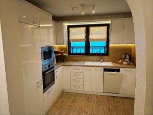 a kitchen with white cabinets and a sink and a window at Trend Apart in Burgas City