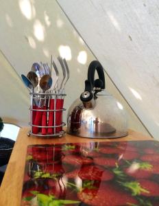 a tea kettle and utensils on a table at Oxford Riverside Glamping in Oxford +33 photos