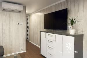 a living room with a television on a white dresser at Weber Hof in Adorf