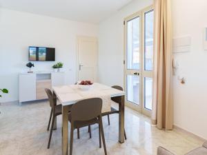 トッレ・パリにあるCasa Fiore Appartamento Superiorのテーブルと椅子のあるキッチンとダイニングルーム