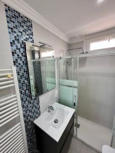 Un baño blanco con lavabo y ducha. en BEACH FRONT APARTMENT in CALA MARSAL with the SEA VIEW !, en Portocolom 50 fotos más