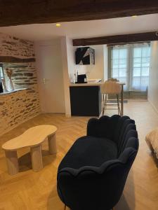 a living room with a chair and a table at Ombre et Douceur in Josselin