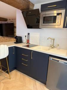 a kitchen with a sink and a microwave at Ombre et Douceur in Josselin +8 photos