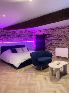 una camera con letto e illuminazione viola di Ombre et Douceur a Josselin