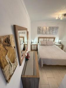 a bedroom with a bed and a mirror on the wall at BEACH FRONT APARTMENT in CALA MARSAL with the SEA VIEW ! in Portocolom