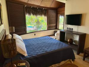 a bedroom with a blue bed and a television at Condomínio Marina Jaguari in Benfica