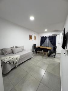 a bedroom with a bed and a dining room at Suite Alem a metros Peatonal San Martin in Paraná