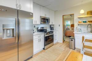 a kitchen with white cabinets and a stainless steel refrigerator at Cozy Cottage Just 2 Blocks From the River! in Colonial Beach +17 photos