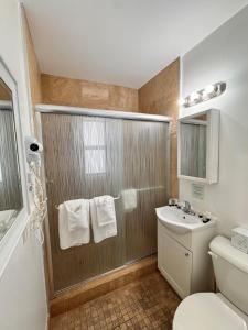 a bathroom with a shower with a sink and a toilet at Coral Key Inn in Fort Lauderdale