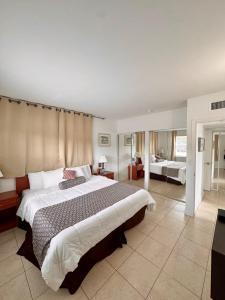 a bedroom with a large bed and a living room at Coral Key Inn in Fort Lauderdale +28 photos