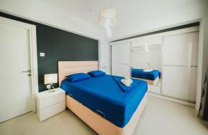 a bedroom with a blue bed and a mirror at Трехкомнатные апартаменты в жилом комплексе Caesar Beach D3 Flat4 in Boğaz