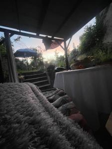 un portico con un letto, delle scale e un ombrellone di Maison de campagne a Barbaste