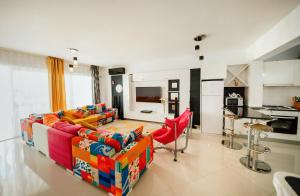 a living room with a couch and red chairs at Трехкомнатные апартаменты в жилом комплексе Caesar Beach D3 Flat4 in Boğaz