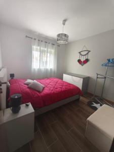 a bedroom with a bed with a red comforter at Casa la Grenadine in Esmoriz