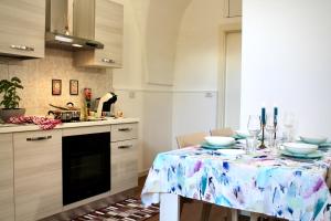 a kitchen with a table with plates and wine glasses at Ginetta House in Ordona