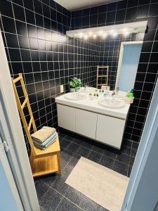 a bathroom with two sinks and a mirror and a chair at Villa Elise in Ostend