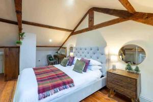 a bedroom with a large white bed and a mirror at Tranquil Appleby Retreat for 6 Guests with Hot Tub in Appleby