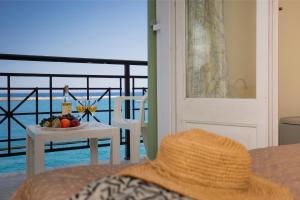 a straw hat sitting on a couch with a table with fruit at Samaina Port Hotel in Karlovasi