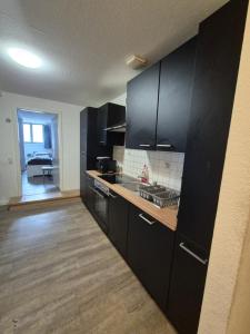 Una cocina con gabinetes negros y encimera. en Monteurredsidenz Wismar - grosartig aufzeit, en Wismar