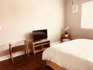 a bedroom with a bed and a tv and a chair at Rowland Heights in Otterbein