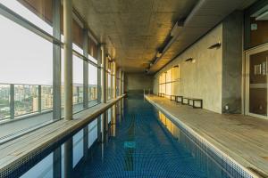 an empty swimming pool in a building with windows at Acrópole Studio - Vaga, Wifi e Piscina no Brooklin in Sao Paulo