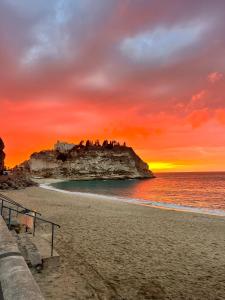 a view of a beach with a sunset at La Romantique Rooms and Apartments TROPEA in Parghelia