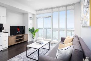 a living room with a couch and a tv at Stylish Condo Downtown by Rogers Centre in Toronto