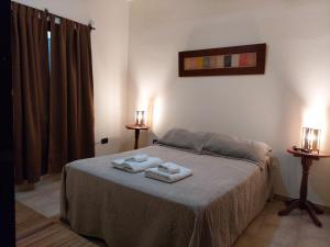 a bedroom with a bed with two towels on it at Hostal Tierra del Sol in Salta