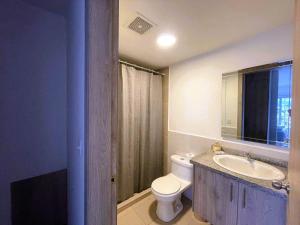 a bathroom with a toilet and a sink and a mirror at Departamento cerca Solca, Embajada Americana y Estadio Atahualpa con vista al COTOPAXI y la CIUDAD in Quito +17 photos