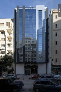 um prédio alto com carros estacionados na frente dele em Marina sweet em Tânger