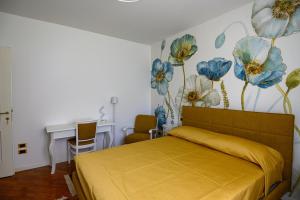 パデンゲ・スル・ガルダにあるVilla Loredoのベッドルーム1室(花の壁画が壁に施されたベッド1台付)