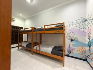 two bunk beds in a room with a mural at Ijen Vibe's Inn in Banyuwangi
