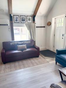 a living room with a leather couch and a window at Watershed- IN TOWN walk to everything in Lava Hot Springs +8 photos