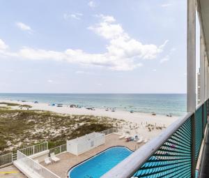 a balcony with a view of a beach and a swimming pool at Beachfront Escape Pool Decks Jacuzzi Tub in Panama City Beach