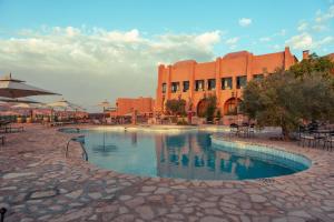 a large swimming pool in front of a building at Tamerza Palace By Odyssée in Tamaghzah