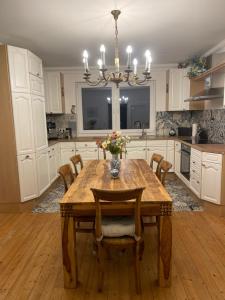 kuchnia z drewnianym stołem z krzesłami i żyrandolem w obiekcie Ferienwohnung in Barockstil w mieście Lengerich