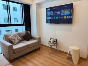 リマにあるTyB apartmentのソファと薄型テレビのあるリビングルーム