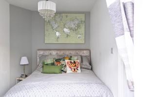 a bedroom with a white bed with green pillows at Modern Medway Bungalow - 3BR Garden & Free Parking, Kent in Rainham