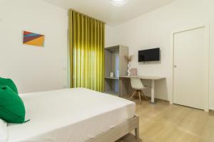 a bedroom with a bed and a desk with a computer at Greco Rooms in Pompei