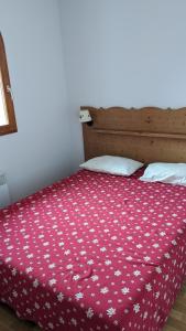 a bedroom with a bed with a red comforter at Appartement 3 pieces 6 personnes, 2 chambres, avec piscine l'été et au pied des pistes l'hiver in Arvieux +27 photos